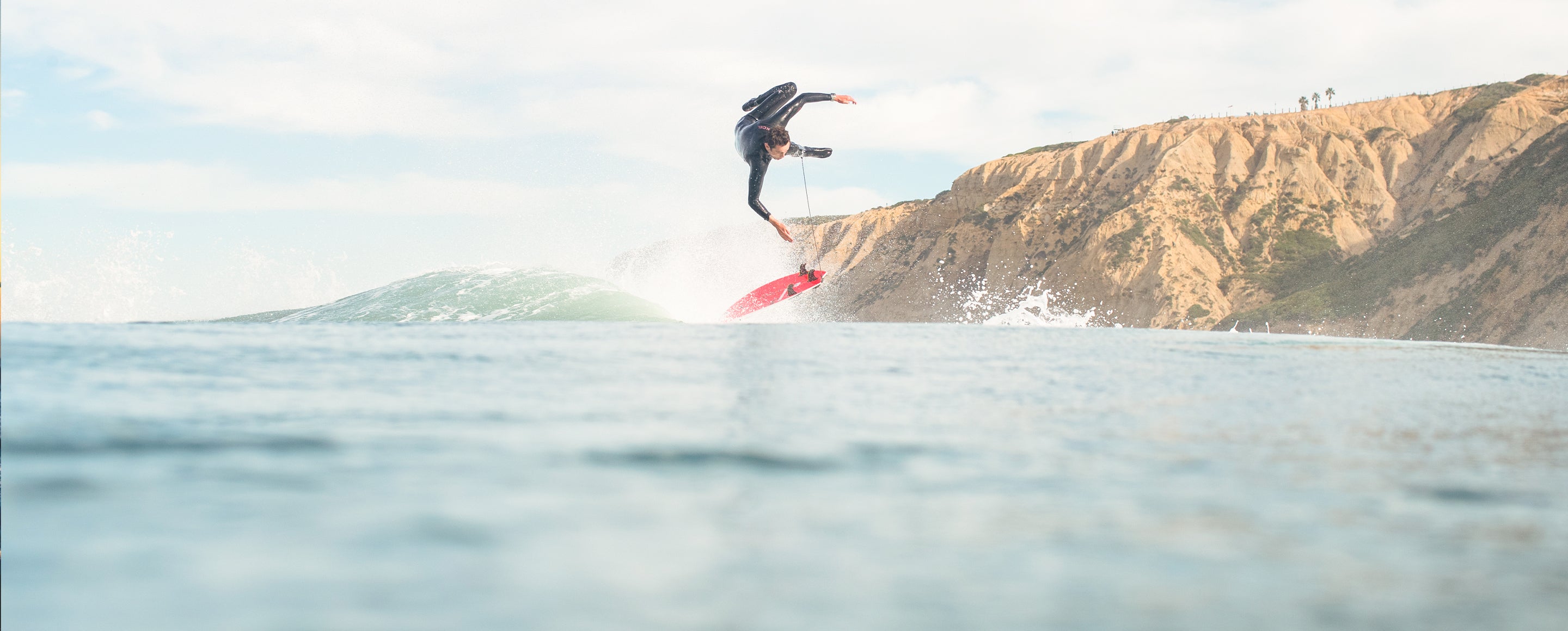 A surfer gets tossed off his board while surfing the coast.
